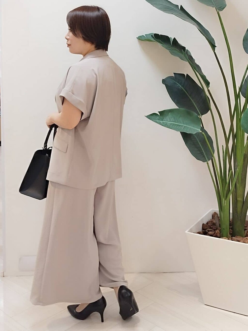 ベージュ系のテーラードジャケット、ブラック系のTシャツ/カットソー、ベージュ系のその他パンツを着用したレディースの夏コーディネートの6枚目の写真