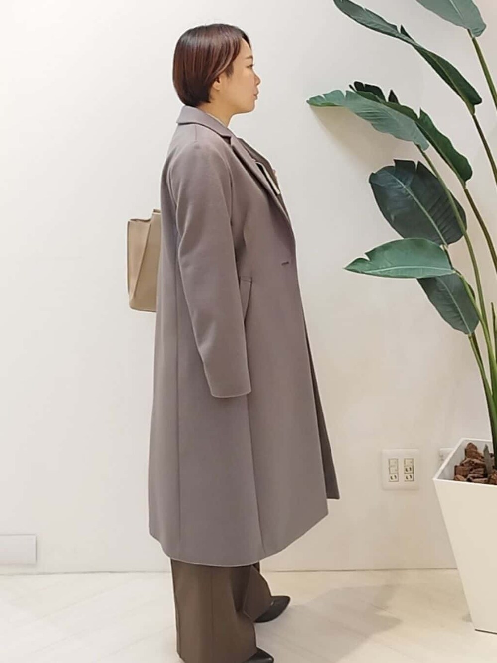 グレー系のチェスターコート、ベージュ系のシャツ/ブラウス、ブラウン系のその他パンツを着用したレディースの冬コーディネートの4枚目の写真