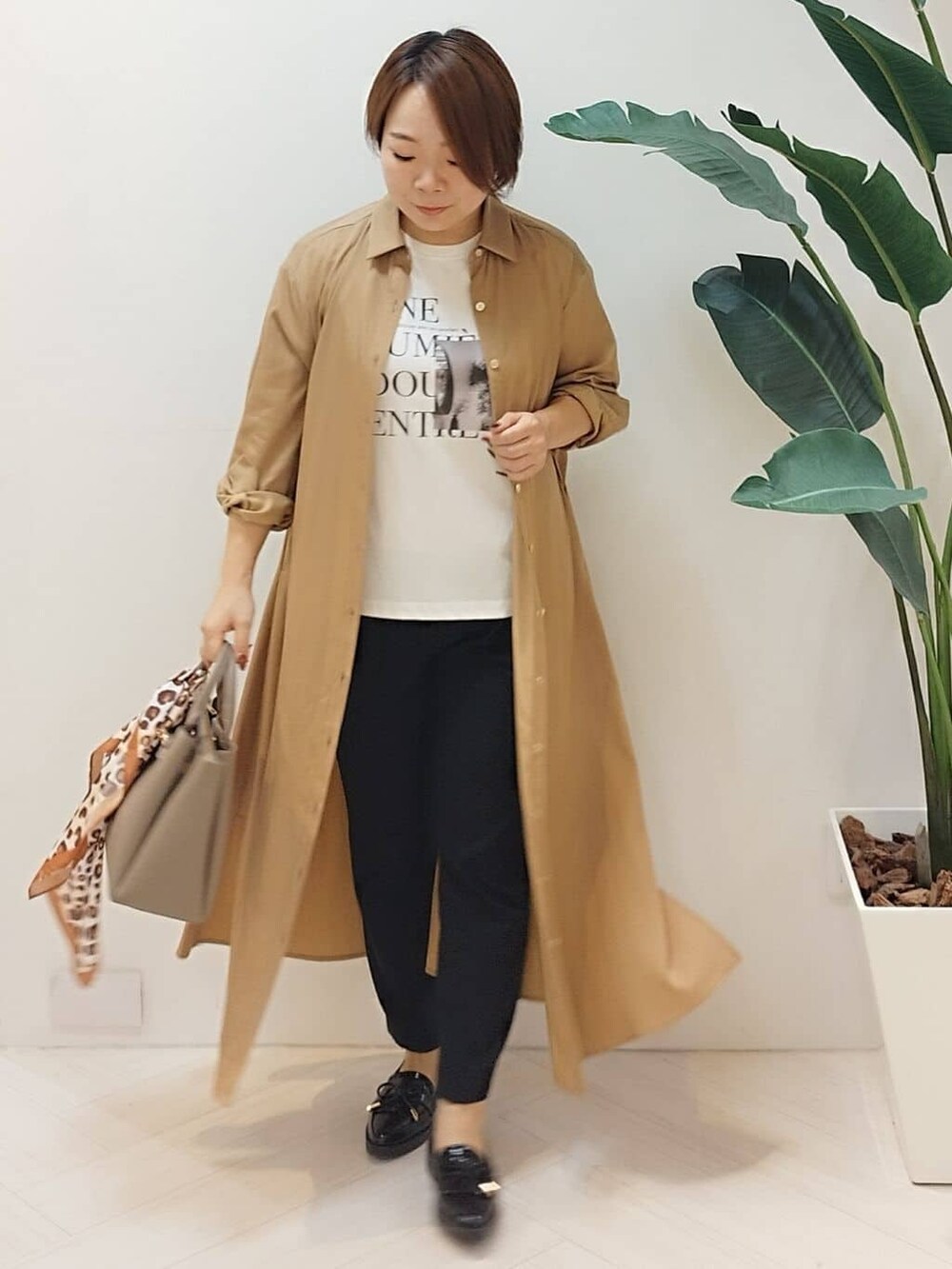 イエロー系のワンピース、ホワイト系のTシャツ/カットソー、ブラック系のその他パンツを着用したレディースの秋コーディネートの2枚目の写真