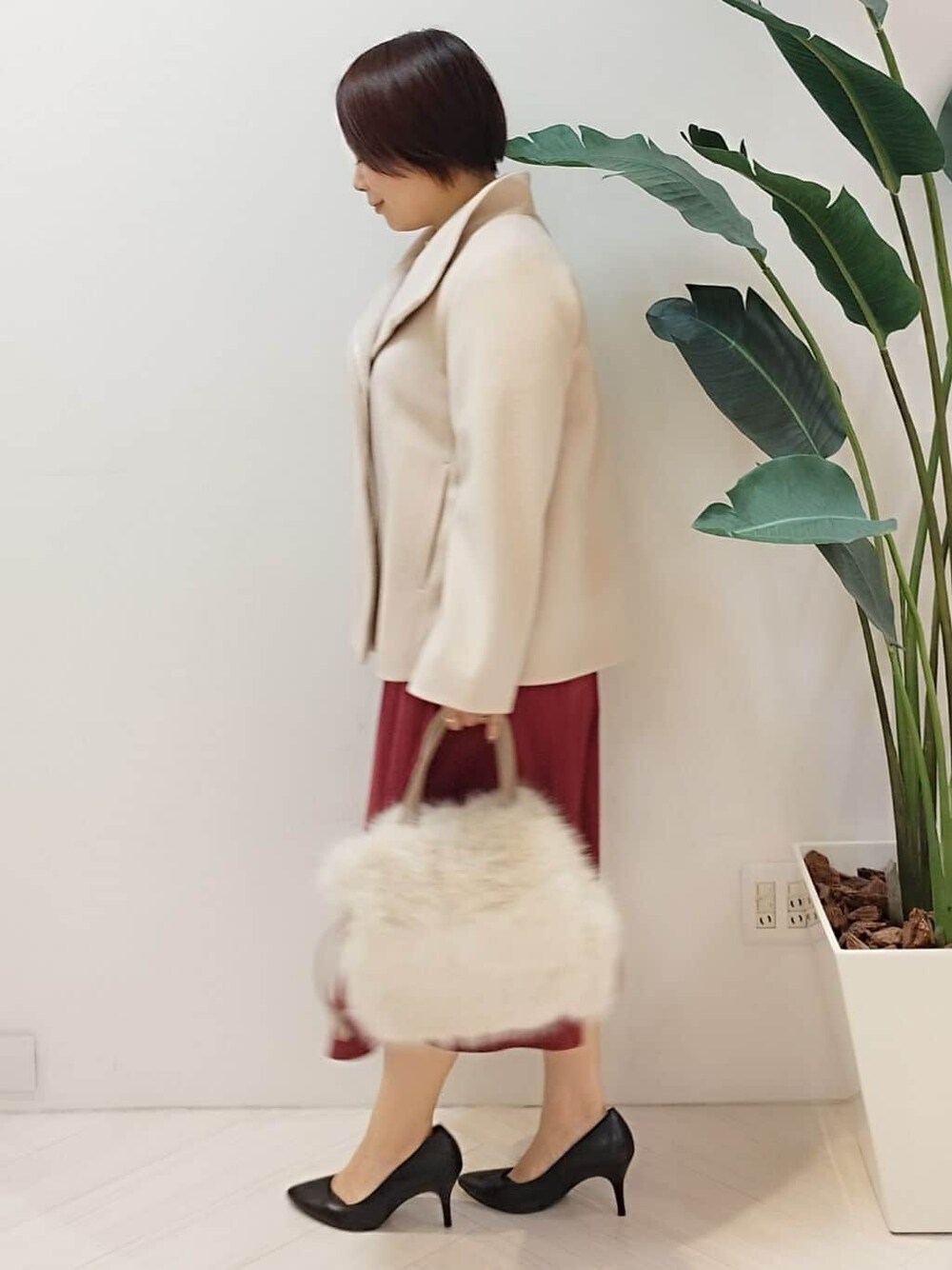 ベージュ系のその他アウター、ベージュ系のニット/セーター、レッド系のスカートを着用したレディースの冬コーディネートの5枚目の写真