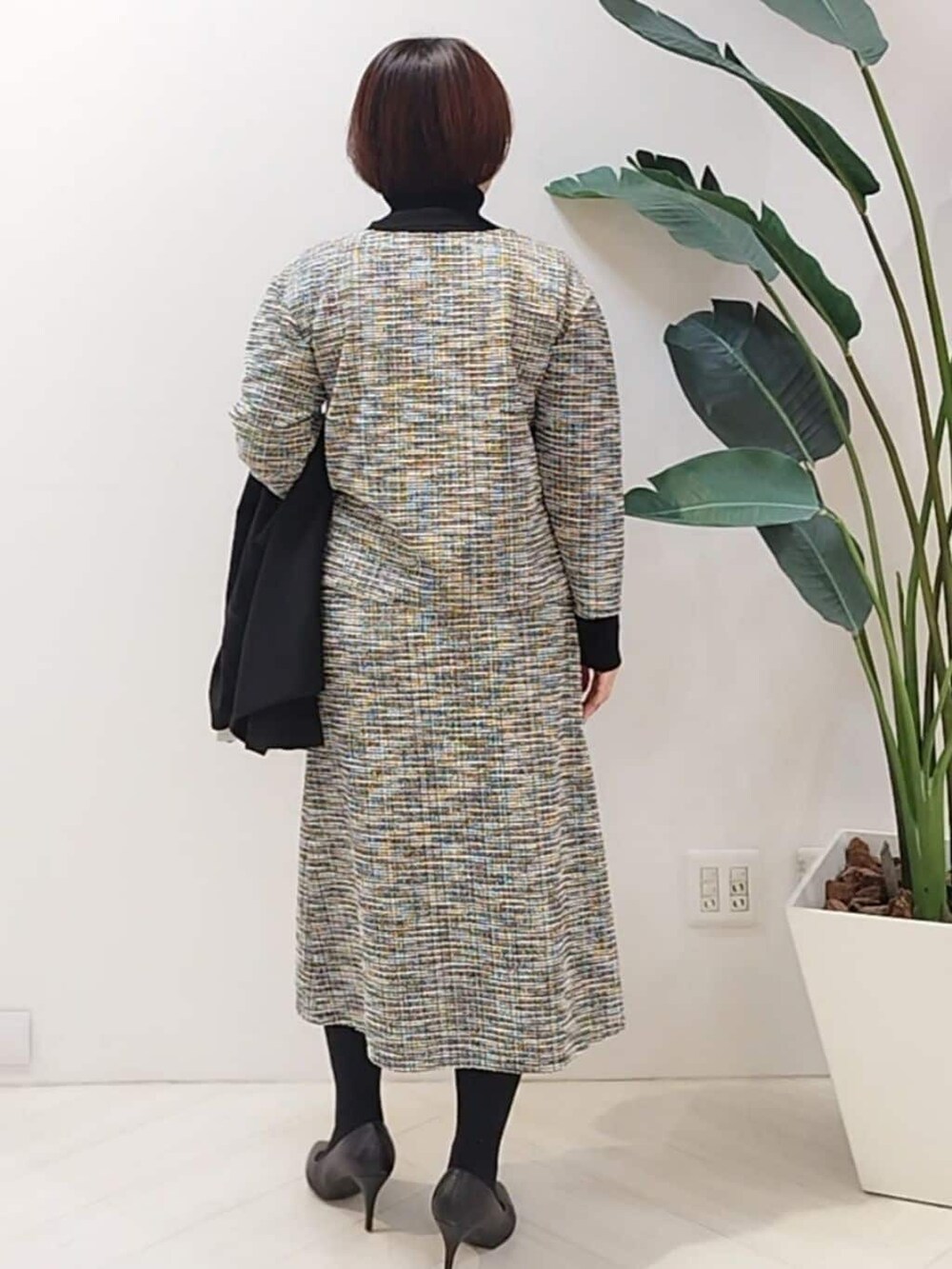 ブラック系のTシャツ/カットソー、ブラック系のスカート、ブラック系のニット/セーターを着用したレディースの秋コーディネートの5枚目の写真