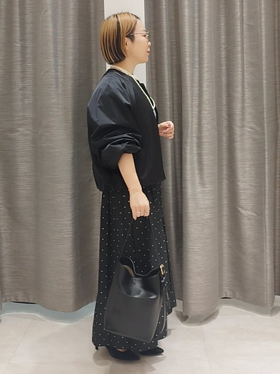 ホワイト系のTシャツ/カットソー、ブラック系のスカート、ブラック系のショルダーバッグを着用したレディースの秋コーディネートの5枚目の写真