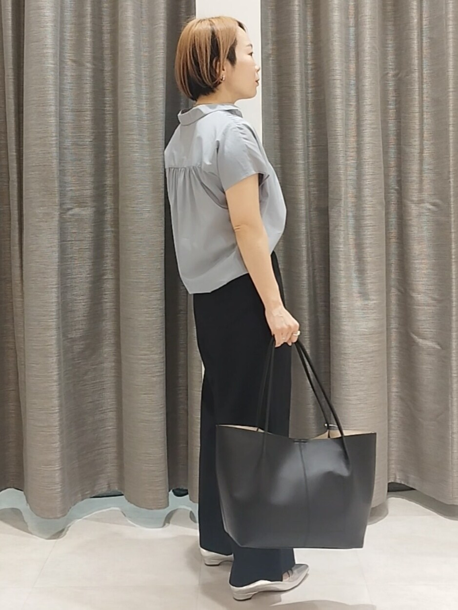 シルバー系のその他シューズ、ブルー系のシャツ/ブラウス、ブラック系のトートバッグを着用したレディースの春コーディネートの6枚目の写真