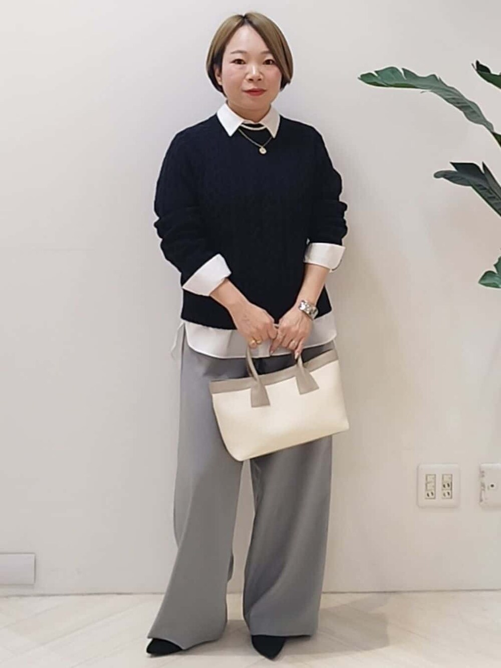 ブルー系のニット/セーター、ホワイト系のシャツ/ブラウス、グレー系のその他パンツを着用したレディースの冬コーディネートの2枚目の写真