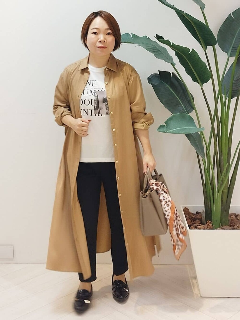 イエロー系のワンピース、ホワイト系のTシャツ/カットソー、ブラック系のその他パンツを着用したレディースの秋コーディネートの3枚目の写真