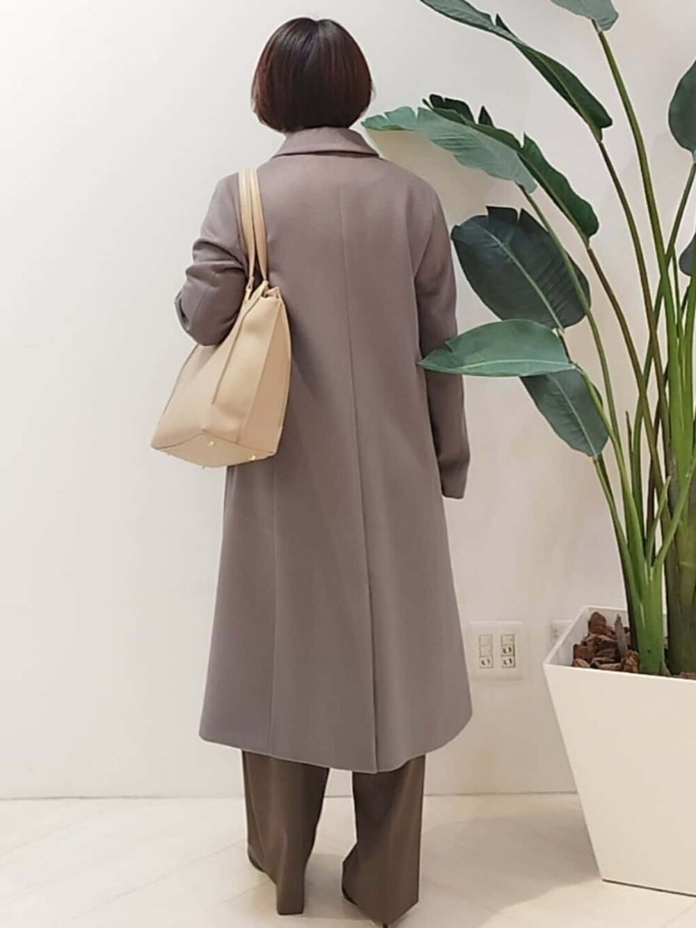 グレー系のチェスターコート、ベージュ系のシャツ/ブラウス、ブラウン系のその他パンツを着用したレディースの冬コーディネートの6枚目の写真