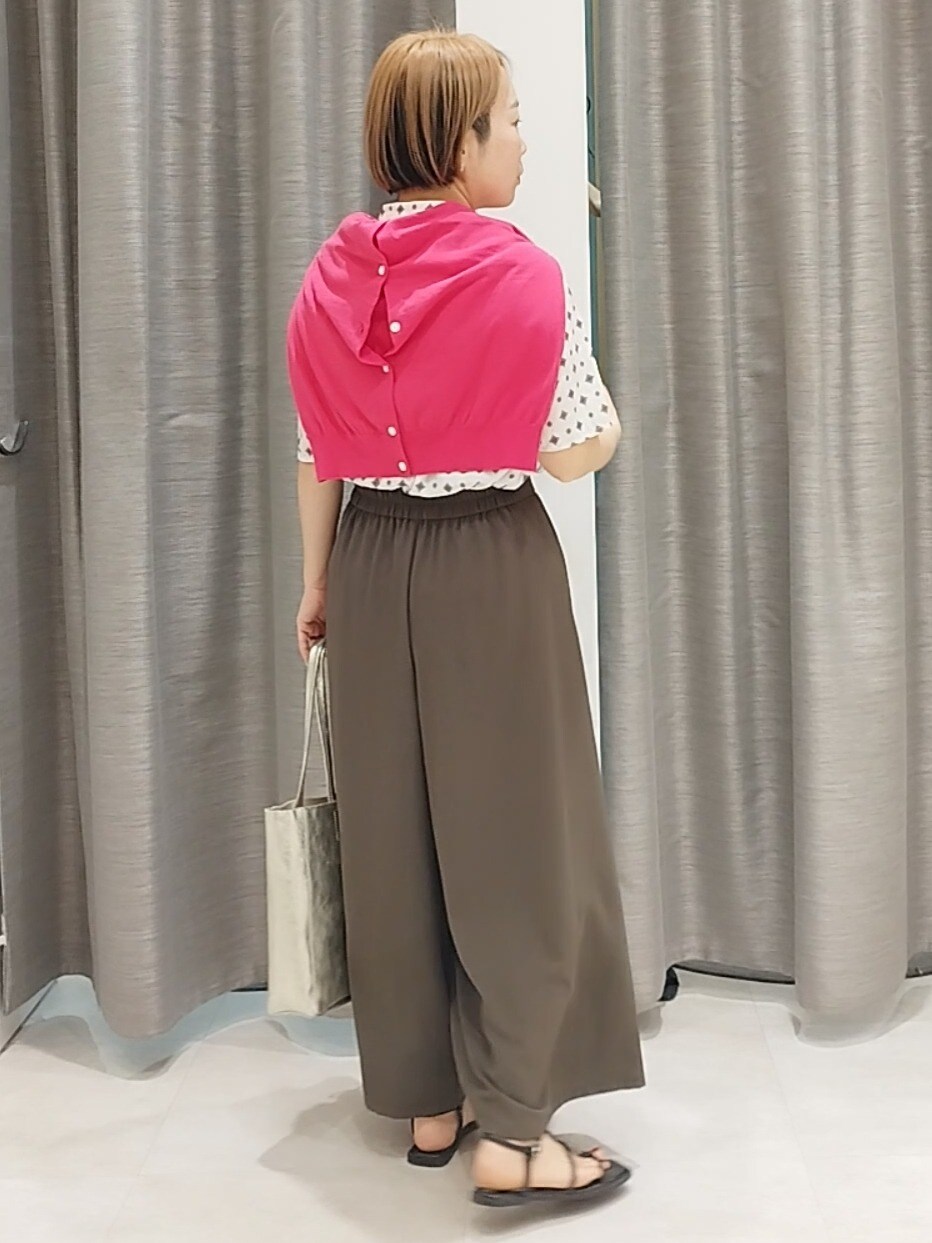 ブラウン系のその他パンツ、ゴールド系のトートバッグ、ピンク系のカーディガン/ボレロを着用したレディースの春コーディネートの6枚目の写真