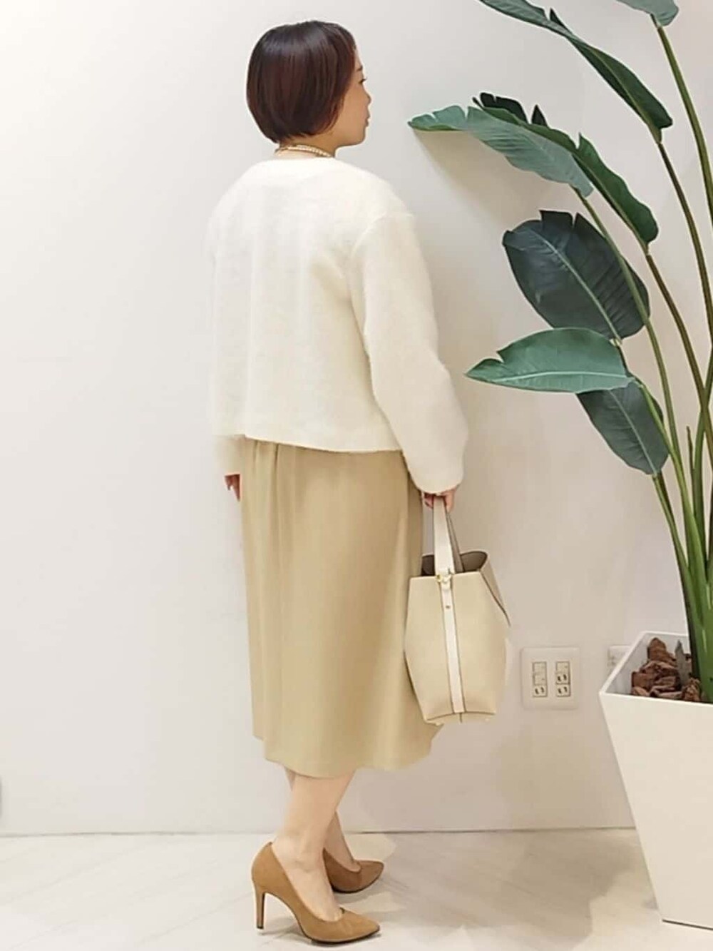 ホワイト系のカーディガン/ボレロ、ベージュ系のワンピース、ベージュ系のショルダーバッグを着用したレディースの秋コーディネートの6枚目の写真