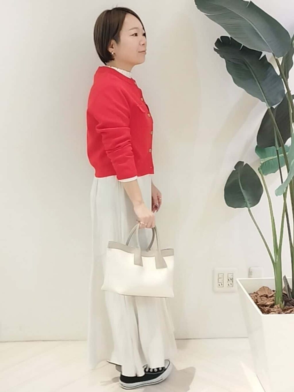 レッド系のカーディガン/ボレロ、ホワイト系のシャツ/ブラウス、ベージュ系のスカートを着用したレディースの春コーディネートの5枚目の写真