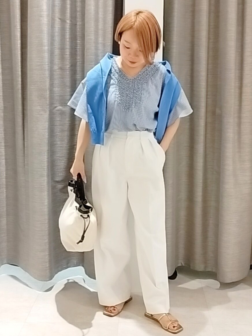 ホワイト系のその他パンツ、ブルー系のカーディガン/ボレロ、ベージュ系のトートバッグを着用したレディースの春コーディネートの3枚目の写真