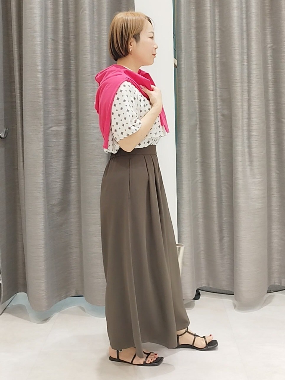 ブラウン系のその他パンツ、ゴールド系のトートバッグ、ピンク系のカーディガン/ボレロを着用したレディースの春コーディネートの3枚目の写真