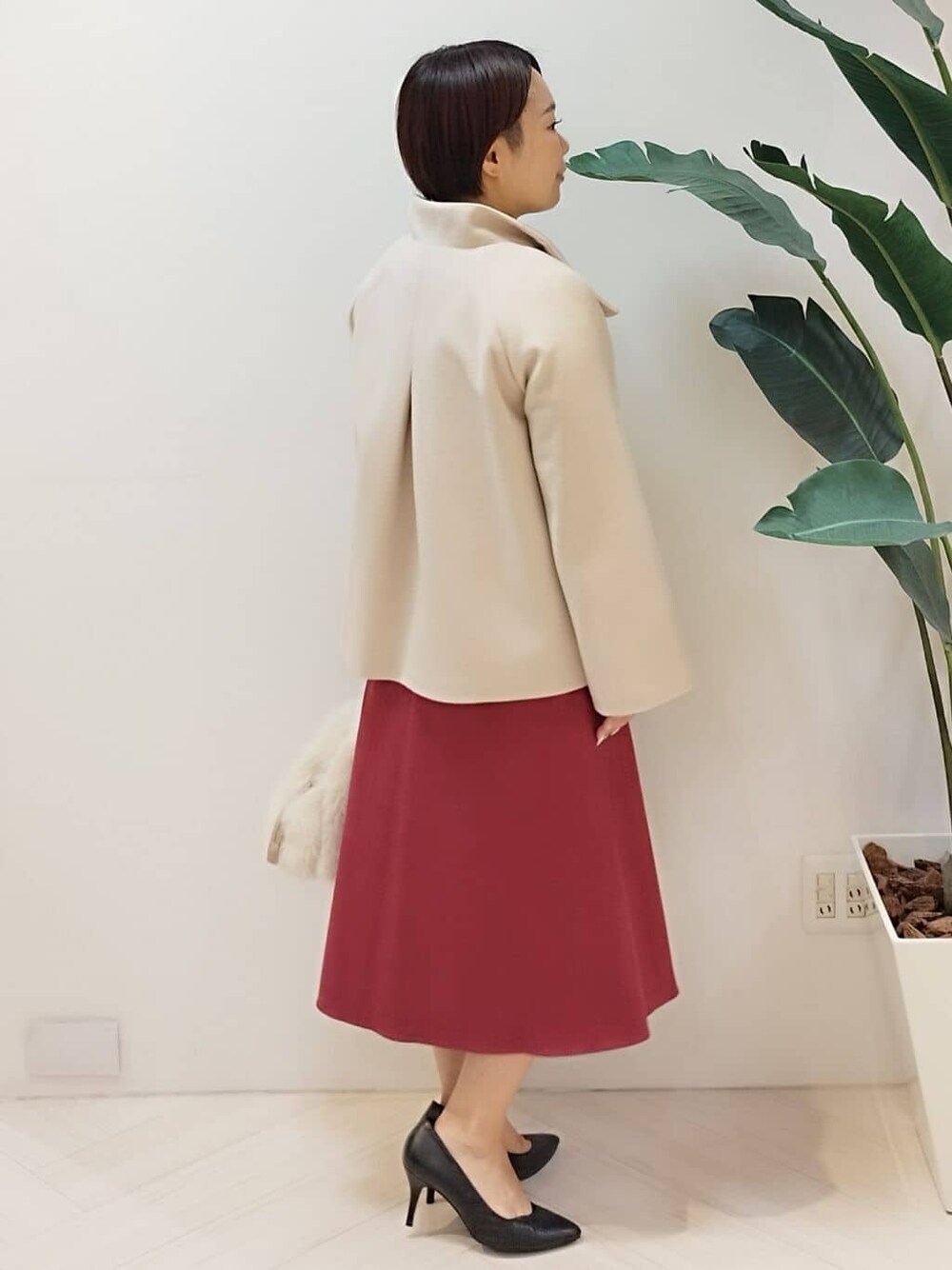 ベージュ系のその他アウター、ベージュ系のニット/セーター、レッド系のスカートを着用したレディースの冬コーディネートの4枚目の写真