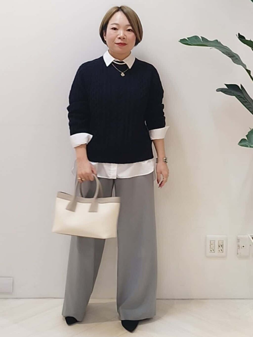 ブルー系のニット/セーター、ホワイト系のシャツ/ブラウス、グレー系のその他パンツを着用したレディースの冬コーディネートの3枚目の写真