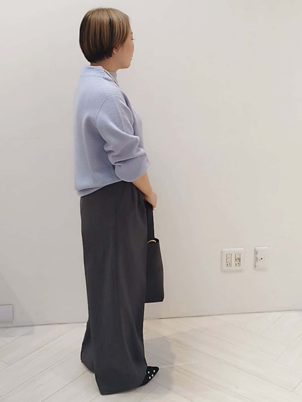 パープル系のニット/セーター、グレー系のその他パンツ、ブラック系のトートバッグを着用したレディースの冬コーディネートの3枚目の写真
