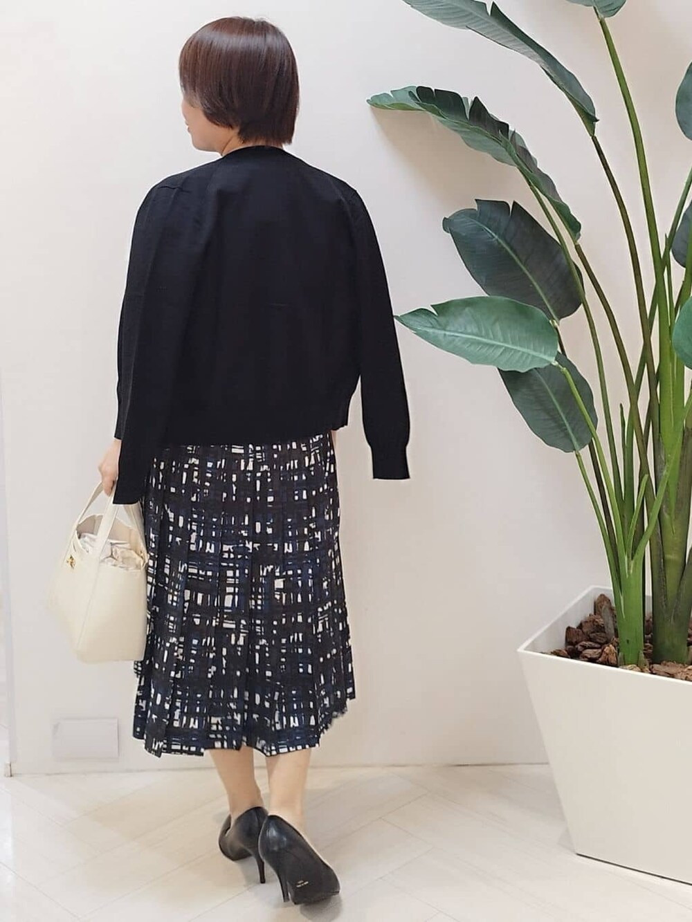 ブラック系のカーディガン/ボレロ、ブラック系のニット/セーター、ブルー系のスカートを着用したレディースの春コーディネートの7枚目の写真
