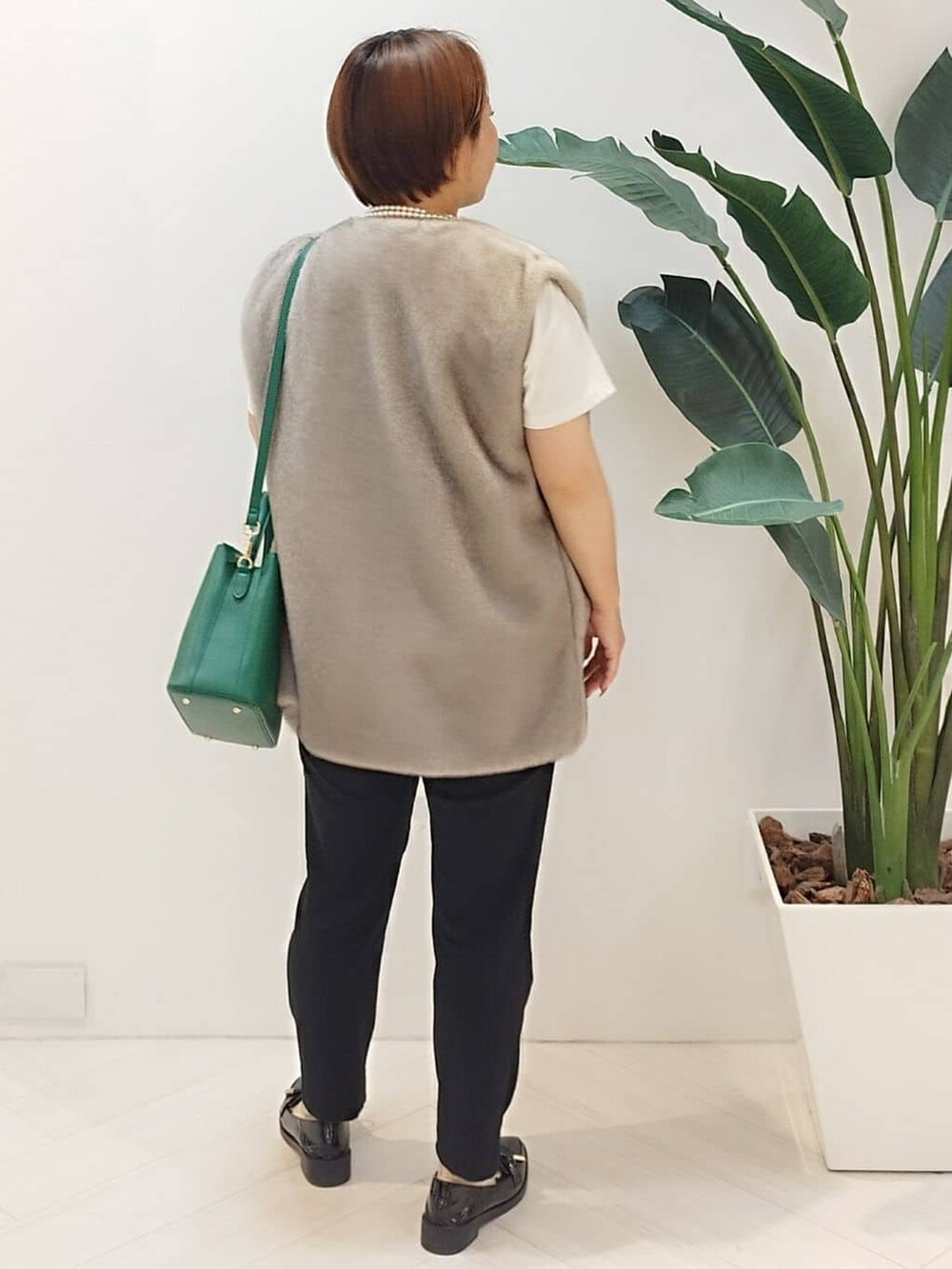 ベージュ系のベスト、ホワイト系のTシャツ/カットソー、ブラック系のその他パンツを着用したレディースの秋コーディネートの7枚目の写真