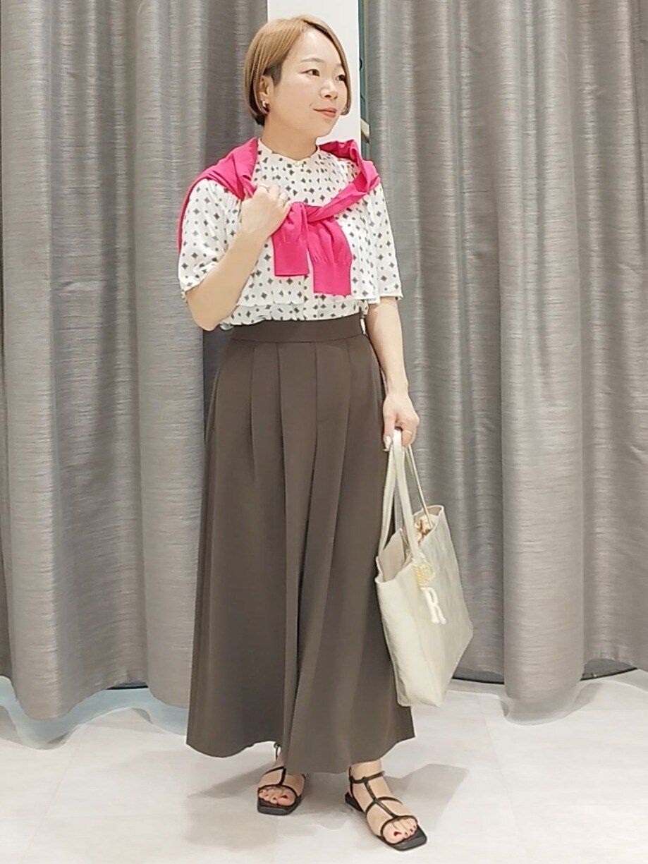 ブラウン系のその他パンツ、ゴールド系のトートバッグ、ピンク系のカーディガン/ボレロを着用したレディースの春コーディネートの2枚目の写真