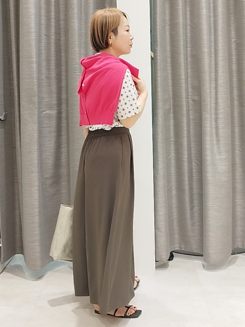 ブラウン系のその他パンツ、ゴールド系のトートバッグ、ピンク系のカーディガン/ボレロを着用したレディースの春コーディネートの5枚目の写真