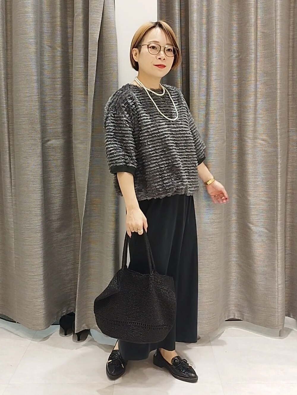 グリーン系のTシャツ/カットソー、ブラック系のスカートを着用したレディースの秋コーディネートの2枚目の写真