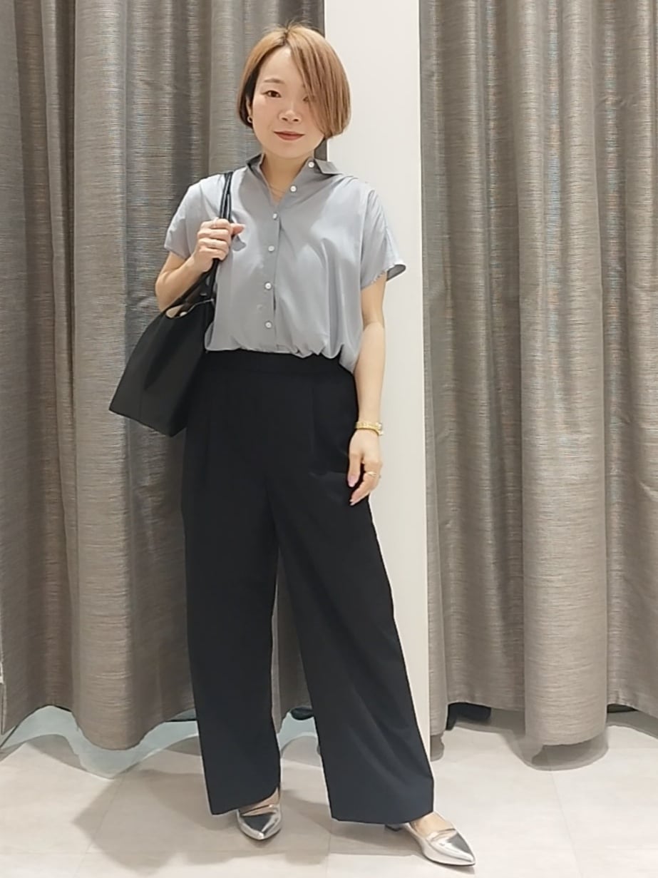 シルバー系のその他シューズ、ブルー系のシャツ/ブラウス、ブラック系のトートバッグを着用したレディースの春コーディネートの2枚目の写真