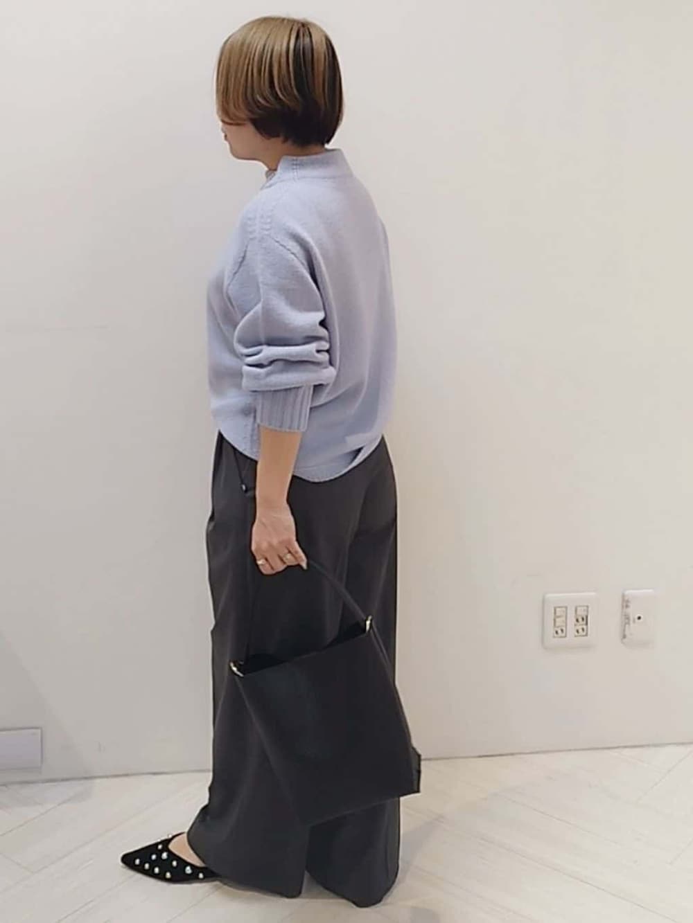 パープル系のニット/セーター、グレー系のその他パンツ、ブラック系のトートバッグを着用したレディースの冬コーディネートの4枚目の写真