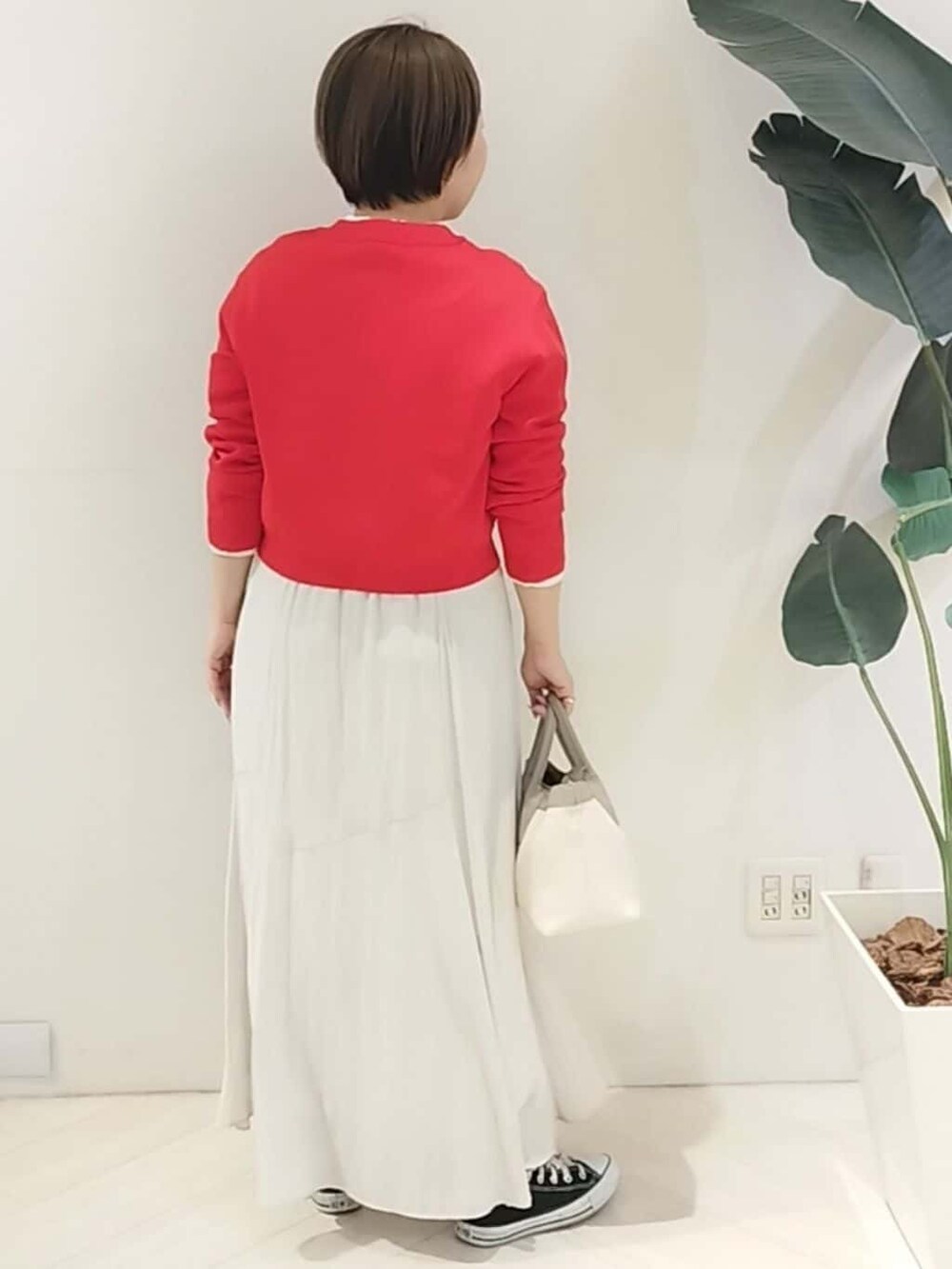 レッド系のカーディガン/ボレロ、ホワイト系のシャツ/ブラウス、ベージュ系のスカートを着用したレディースの春コーディネートの8枚目の写真