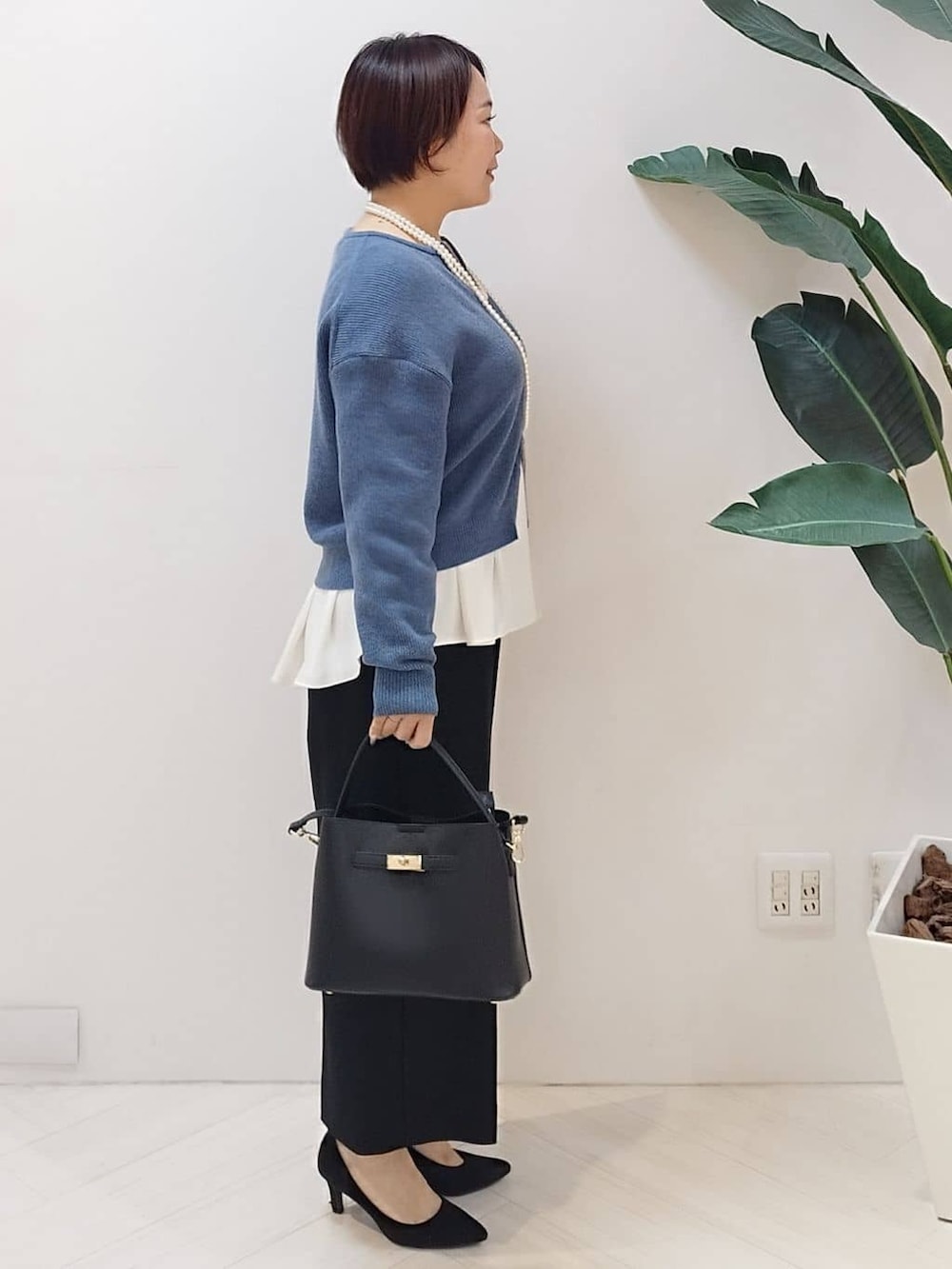 ブルー系のカーディガン/ボレロ、ホワイト系のシャツ/ブラウス、ブラック系のその他パンツを着用したレディースの冬コーディネートの4枚目の写真