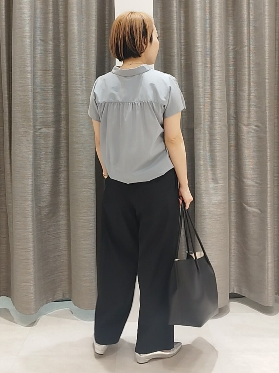シルバー系のその他シューズ、ブルー系のシャツ/ブラウス、ブラック系のトートバッグを着用したレディースの春コーディネートの9枚目の写真
