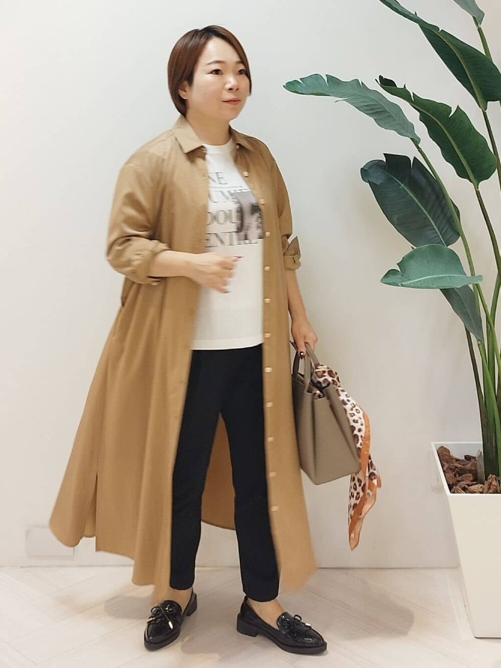 イエロー系のワンピース、ホワイト系のTシャツ/カットソー、ブラック系のその他パンツを着用したレディースの秋コーディネートの4枚目の写真