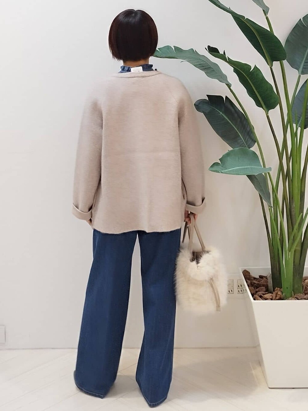 ベージュ系のカーディガン/ボレロ、ブルー系のシャツ/ブラウス、ブルー系のデニムパンツを着用したレディースの冬コーディネートの6枚目の写真