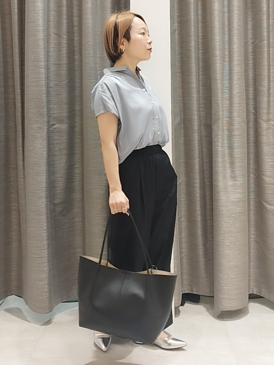 シルバー系のその他シューズ、ブルー系のシャツ/ブラウス、ブラック系のトートバッグを着用したレディースの春コーディネートの5枚目の写真