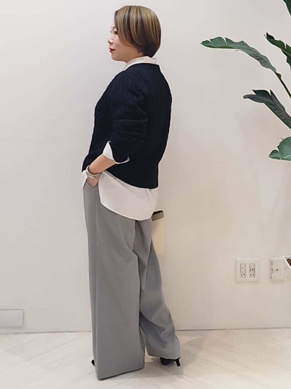 ブルー系のニット/セーター、ホワイト系のシャツ/ブラウス、グレー系のその他パンツを着用したレディースの冬コーディネートの4枚目の写真