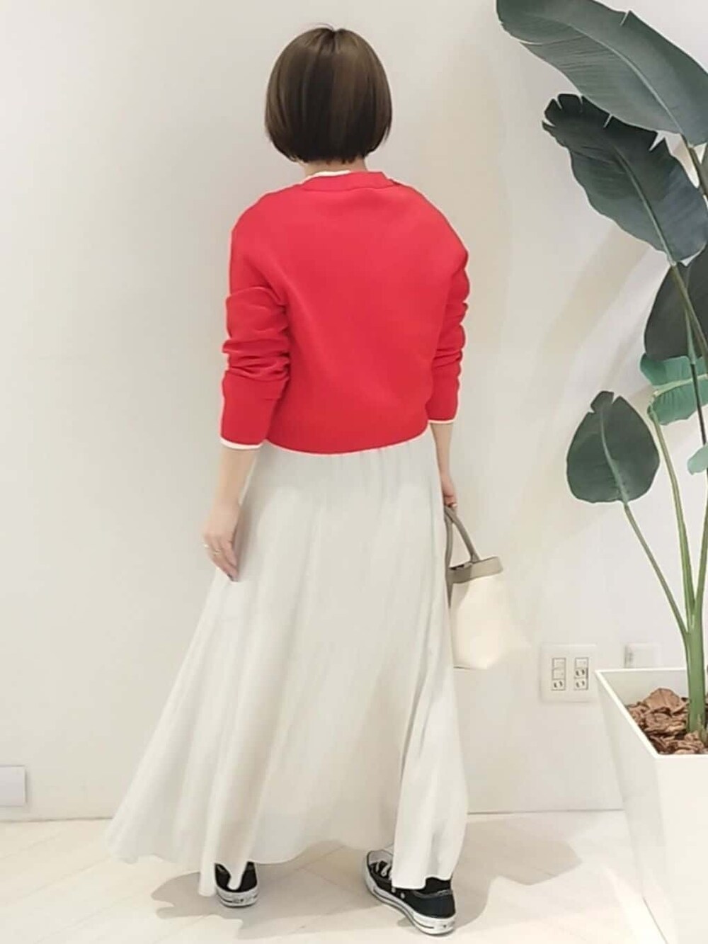 レッド系のカーディガン/ボレロ、ホワイト系のシャツ/ブラウス、ベージュ系のスカートを着用したレディースの春コーディネートの9枚目の写真