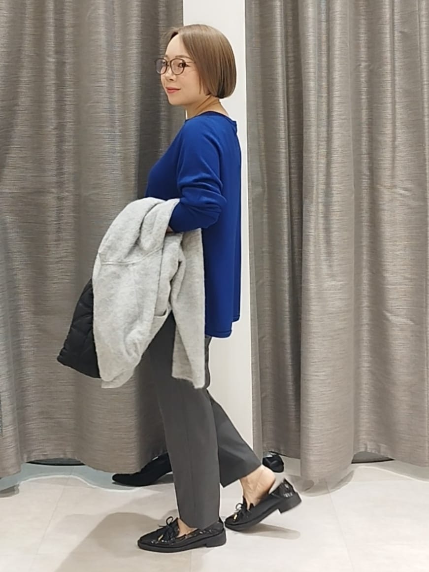 ブルー系のニット/セーター、グレー系のその他パンツ、グレー系のカーディガン/ボレロを着用したレディースの秋コーディネートの4枚目の写真