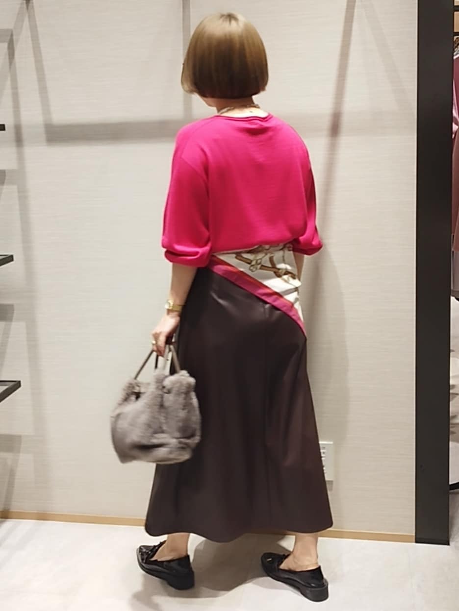 ピンク系のニット/セーター、ブラウン系のハンドバッグ、シルバー系のネックレスを着用したレディースの秋コーディネートの5枚目の写真