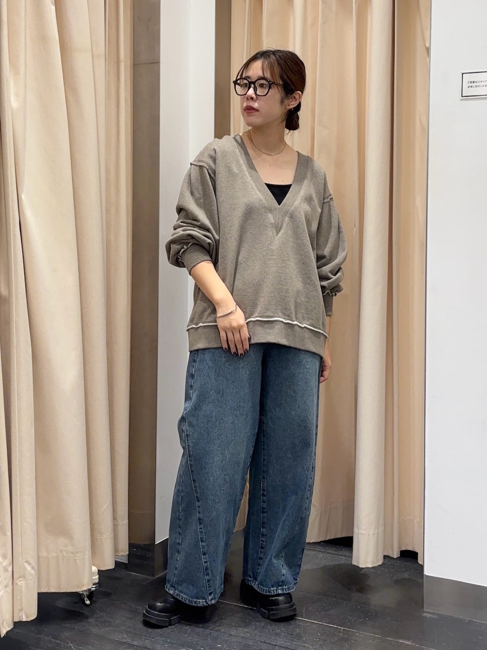 ベージュ系のTシャツ/カットソー、ブルー系のデニムパンツを着用したレディースの秋コーディネートの2枚目の写真