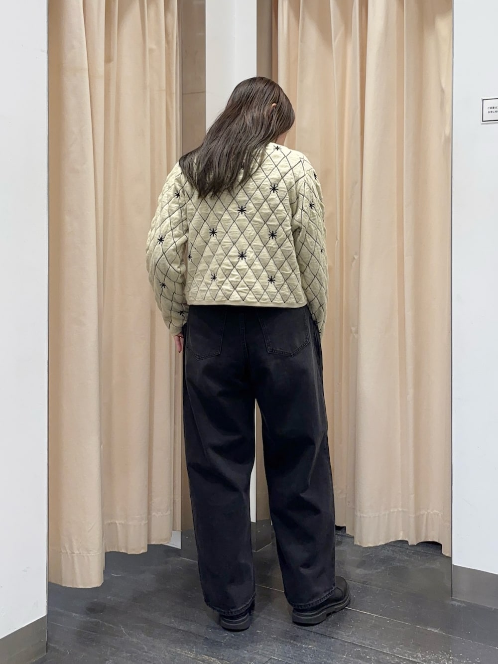 ベージュ系のニット/セーター、ブラック系のデニムパンツを着用したレディースの秋コーディネートの2枚目の写真