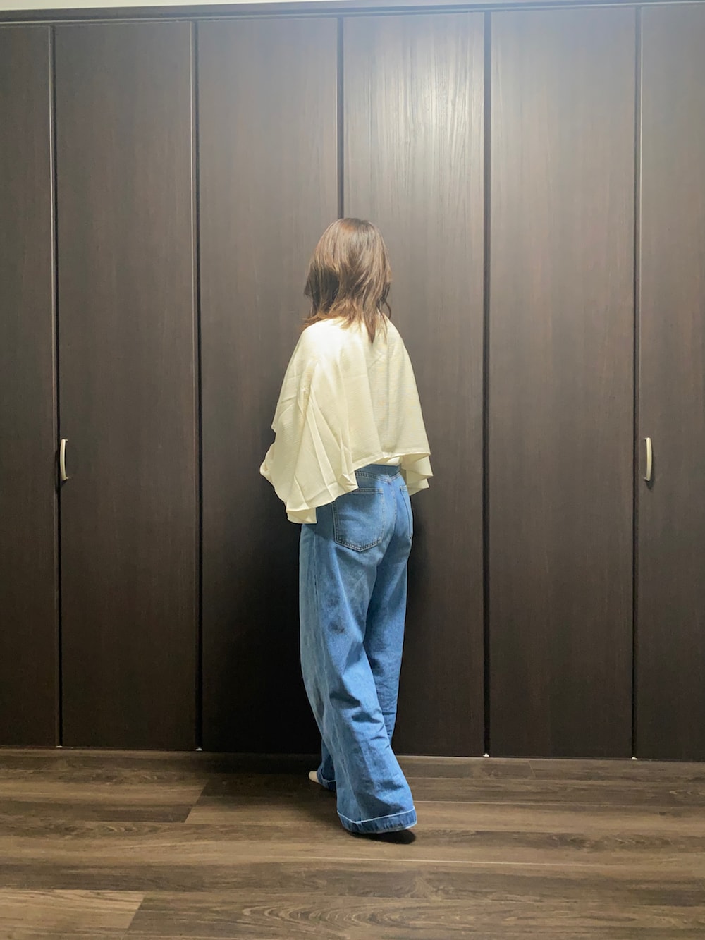 ブルー系のデニムパンツ、ホワイト系のシャツ/ブラウス、ホワイト系のTシャツ/カットソーを着用したレディースの秋コーディネートの2枚目の写真