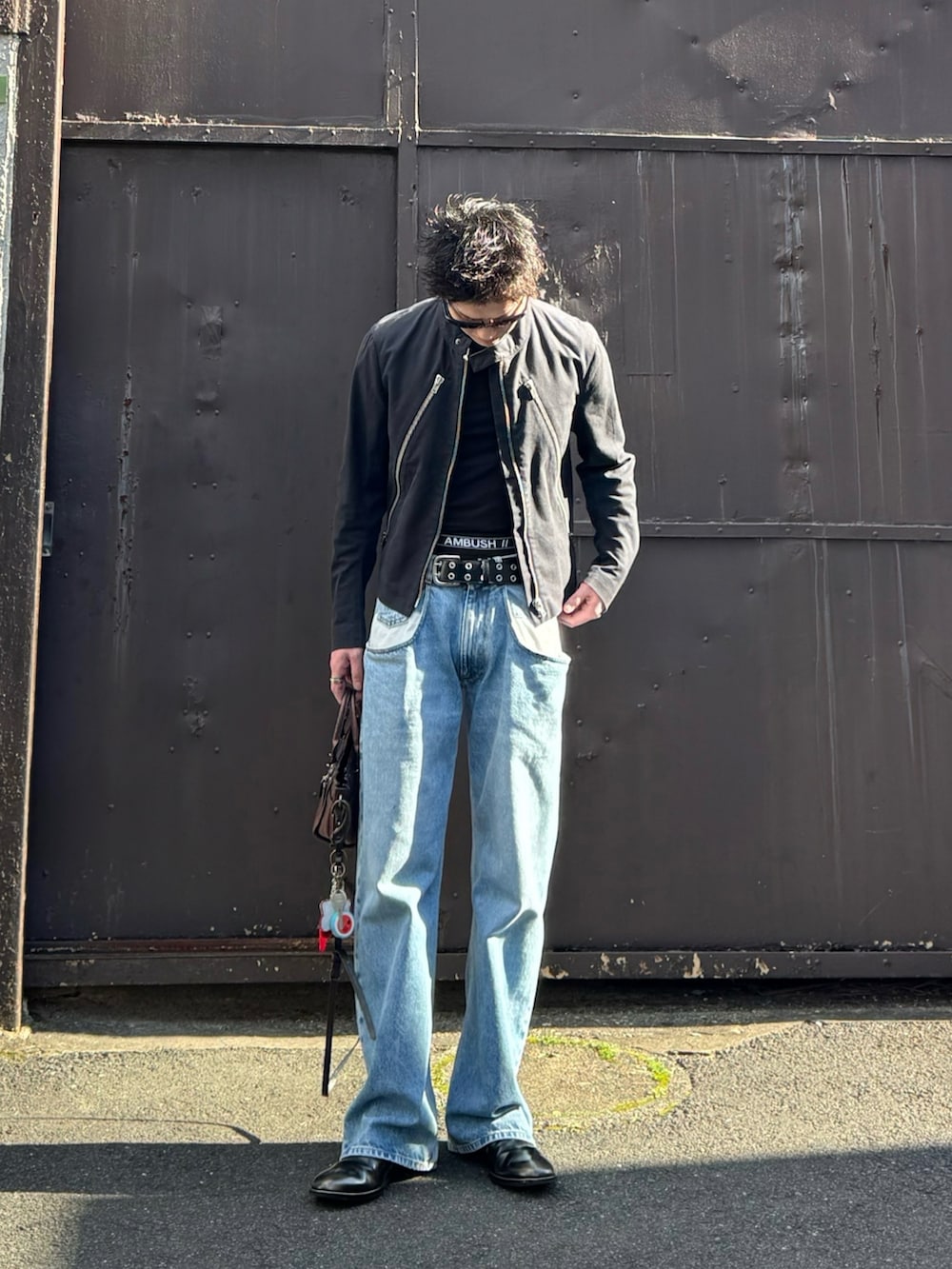 ブラック系のデニムジャケット、ブルー系のデニムパンツ、ブラック系のブーツを着用したメンズの春コーディネートの2枚目の写真