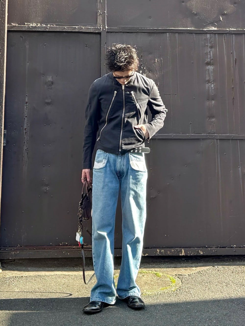 ブラック系のデニムジャケット、ブルー系のデニムパンツ、ブラック系のブーツを着用したメンズの春コーディネートの3枚目の写真