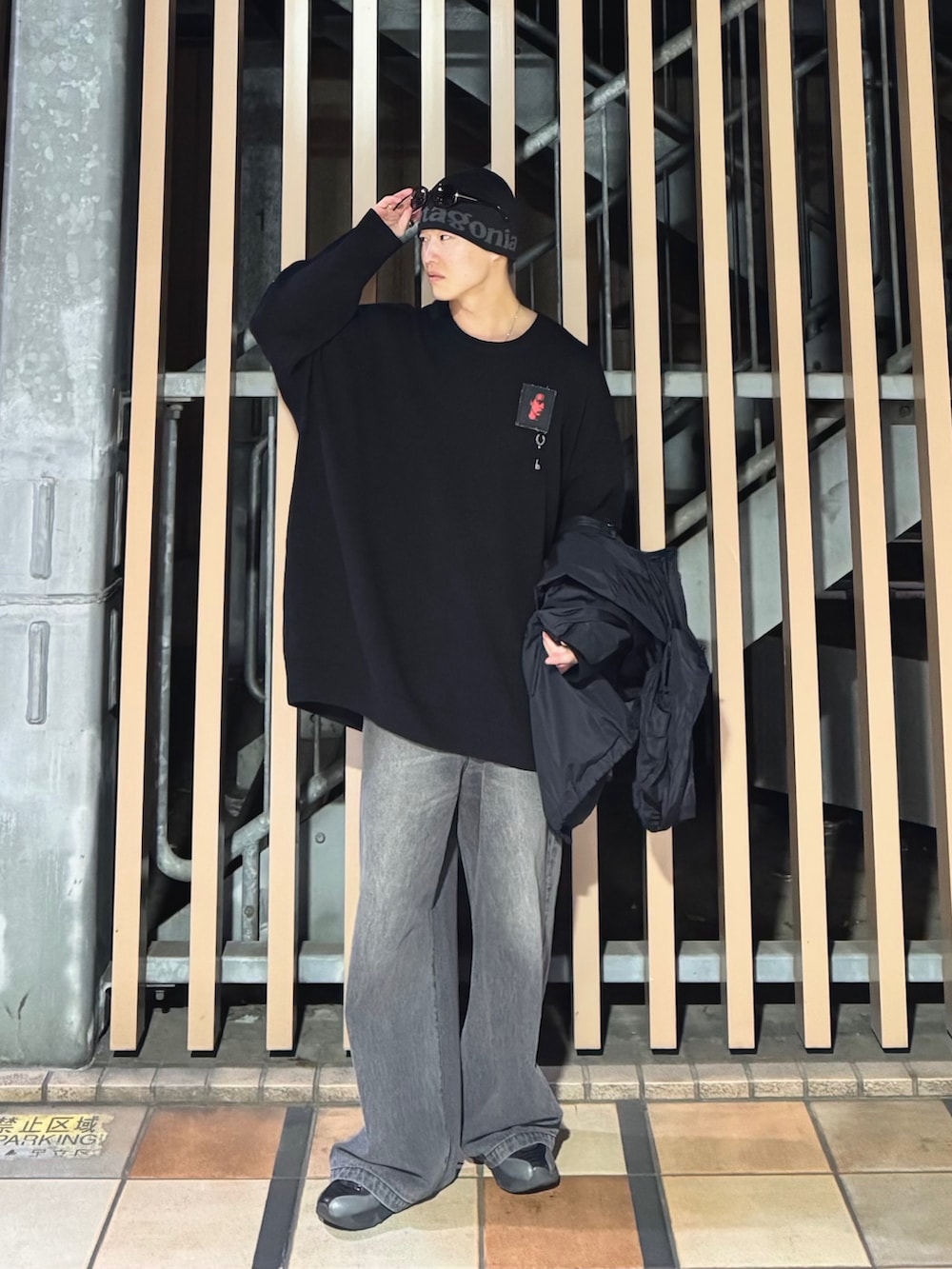 ブラック系のナイロンジャケット、ブラック系のニット/セーター、ブラック系のデニムパンツを着用したメンズの冬コーディネートの3枚目の写真