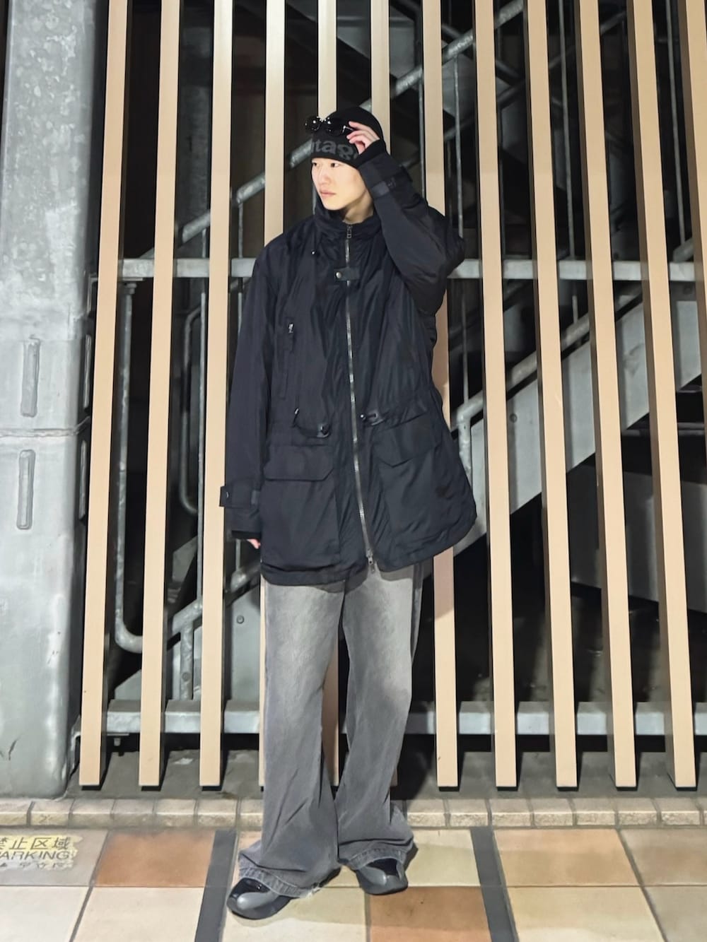 ブラック系のナイロンジャケット、ブラック系のニット/セーター、ブラック系のデニムパンツを着用したメンズの冬コーディネートの2枚目の写真