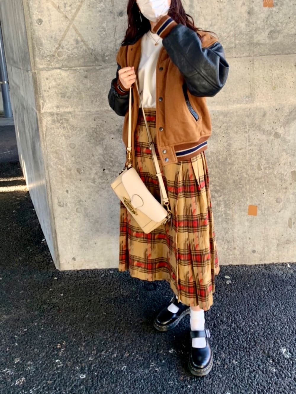 ブラウン系のスカート、ブラック系のブーツを着用したレディースの冬コーディネートの3枚目の写真