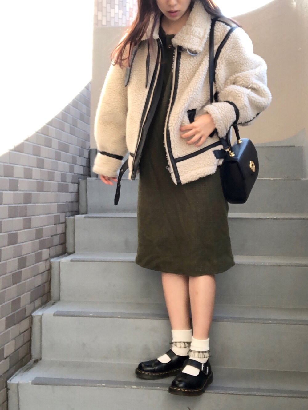 ブラック系のブーツ、ホワイト系のジャケット/アウターを着用したレディースの冬コーディネートの3枚目の写真