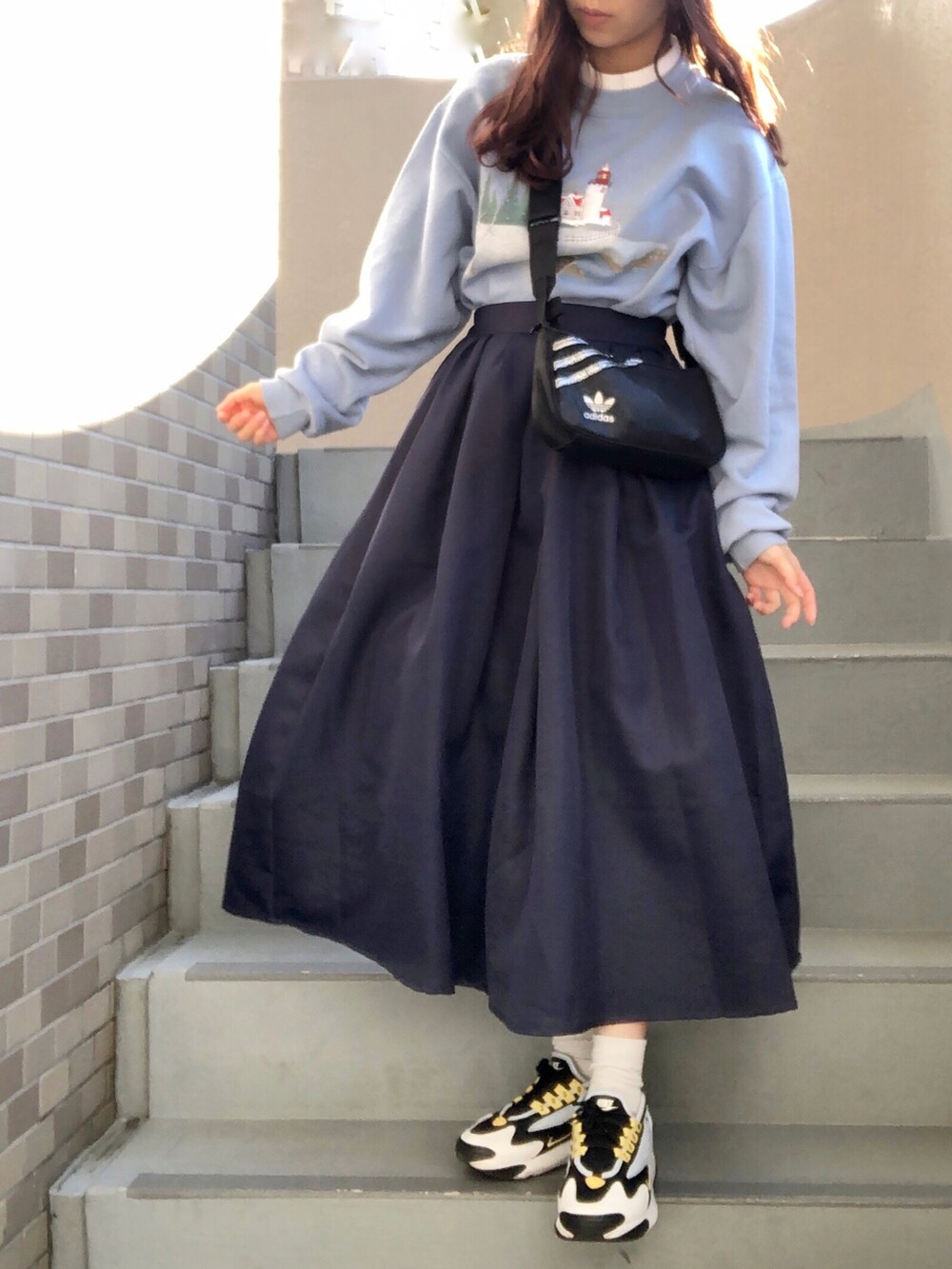 ブラック系のショルダーバッグ、ブルー系のスニーカーを着用したレディースの冬コーディネートの2枚目の写真