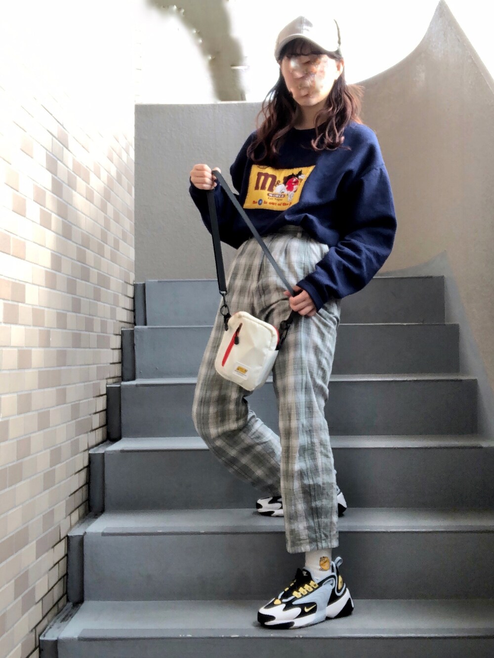 グリーン系のその他パンツ、ブルー系のスニーカー、ホワイト系のキャップを着用したレディースの冬コーディネートの2枚目の写真