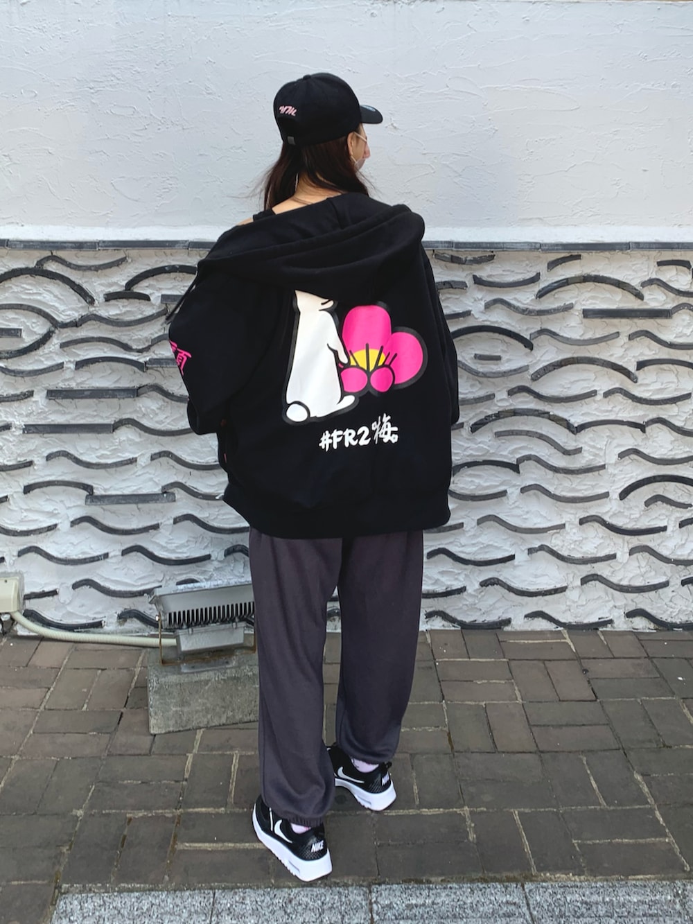 ブラック系のパーカー、ブラック系のスニーカーを着用したレディースの春コーディネートの2枚目の写真