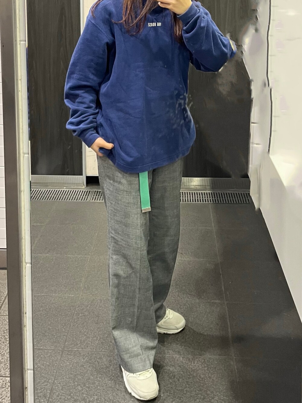 ブルー系のパーカー、ホワイト系のブルゾン、ホワイト系のスニーカーを着用したレディースの冬コーディネートの2枚目の写真