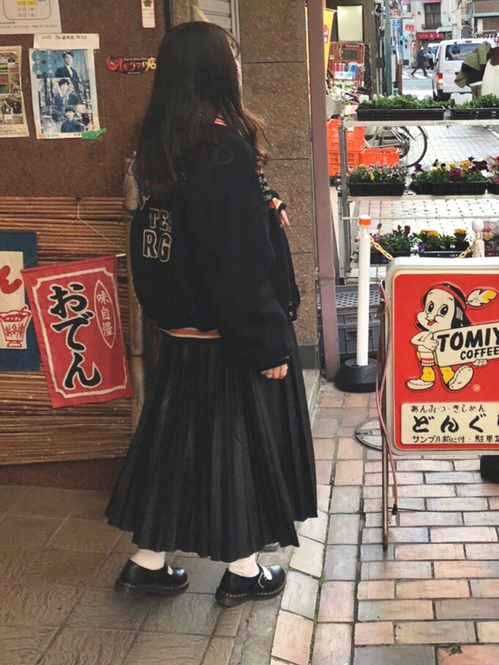 ブラック系のスカート、ブラック系のブーツを着用したレディースの冬コーディネートの2枚目の写真