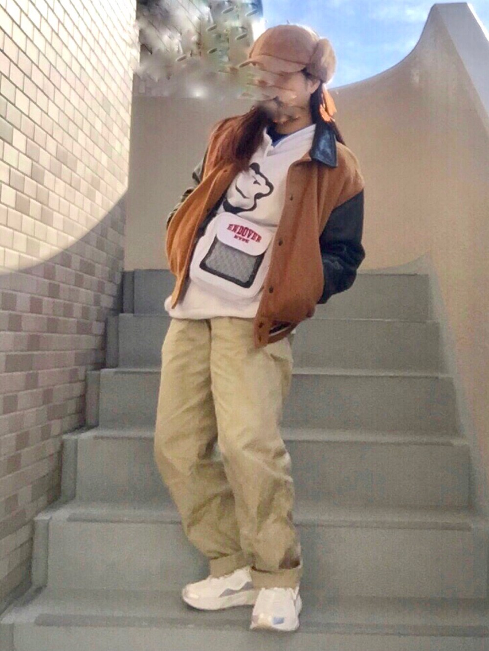 ベージュ系のパンツ、ホワイト系のショルダーバッグ、ホワイト系のスニーカーを着用したレディースの冬コーディネートの2枚目の写真